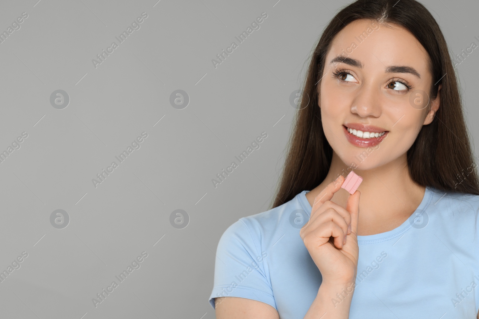 Photo of Woman with bubble gum on grey background. Space for text