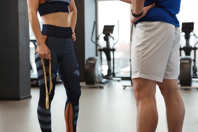 Trainer having discussion with woman in gym, closeup