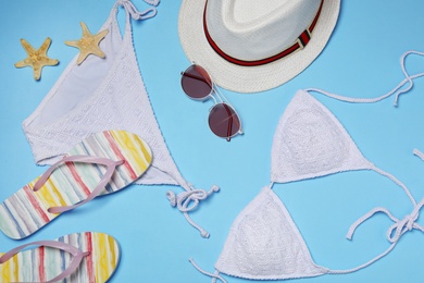 Flat lay composition with stylish bikini on color background. Beach objects