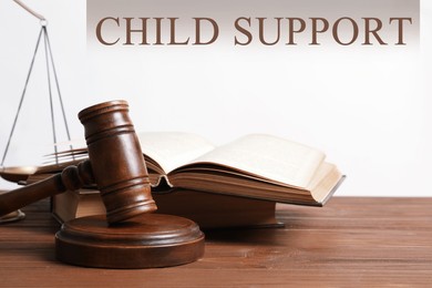 Judge's gavel, scales of justice and books on wooden table. Child support concept