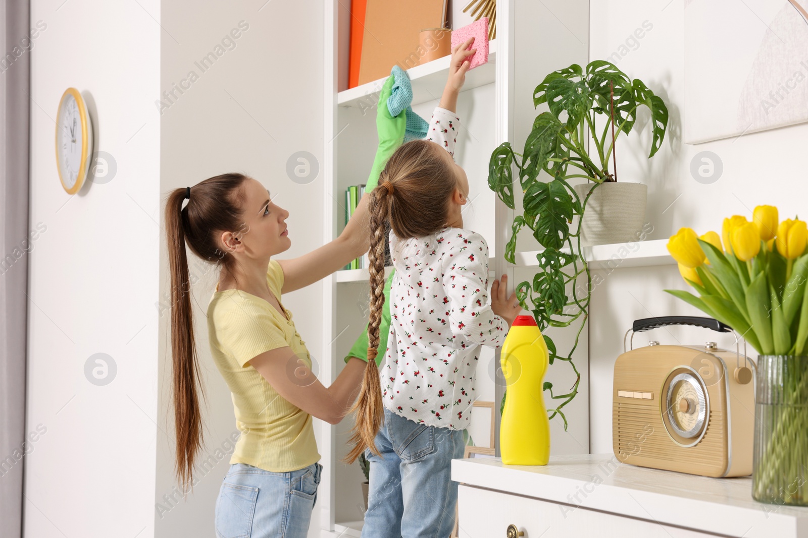 Photo of Spring cleaning. Mother and daughter tidying up together at home