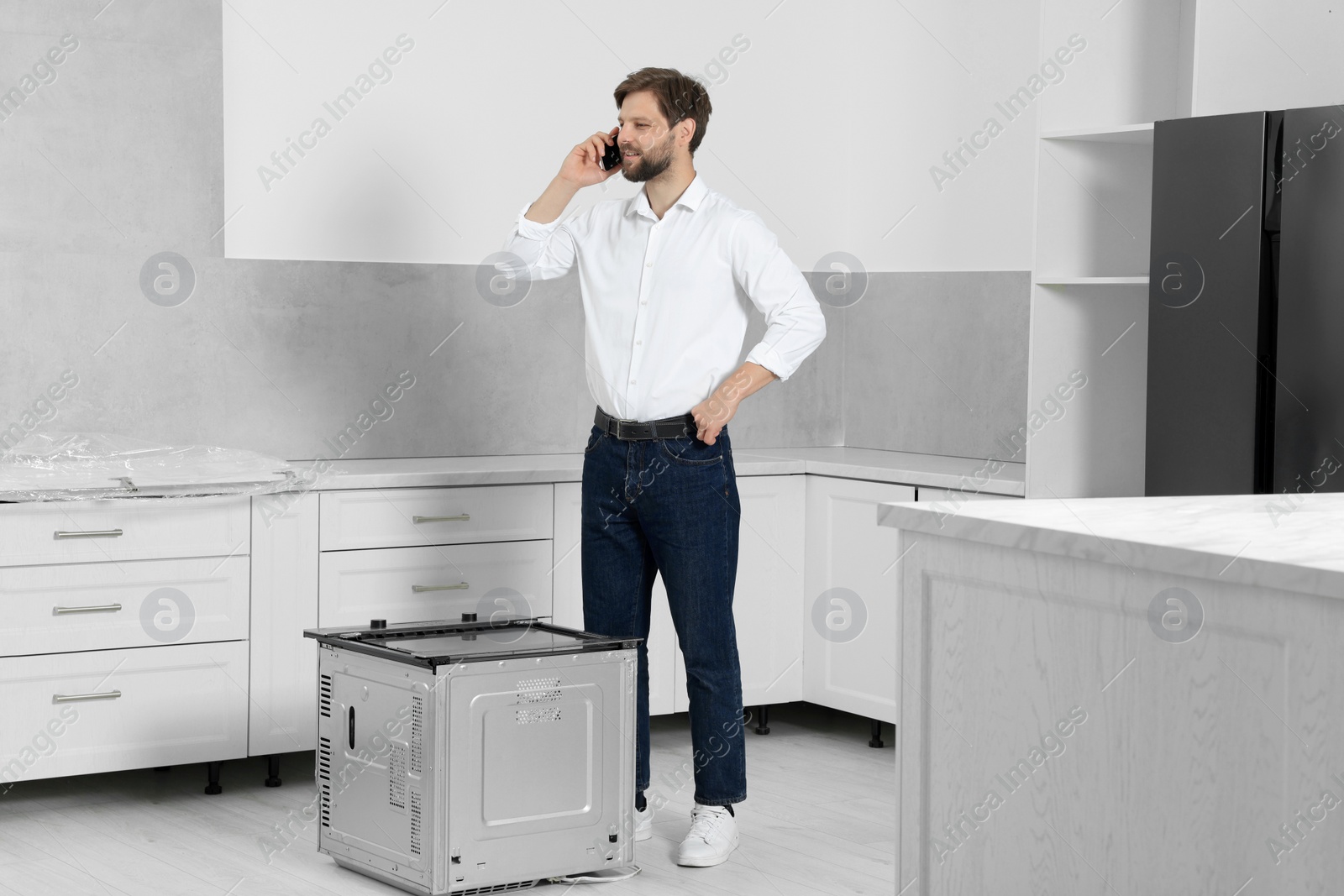 Photo of Man in casual clothes talking on phone indoors