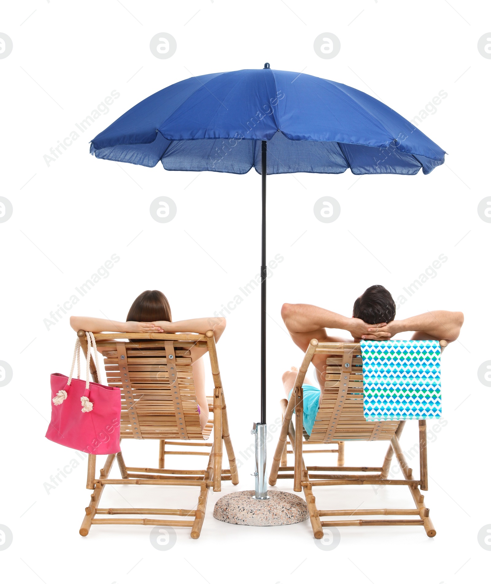 Photo of Young couple with beach accessories on sun loungers against white background