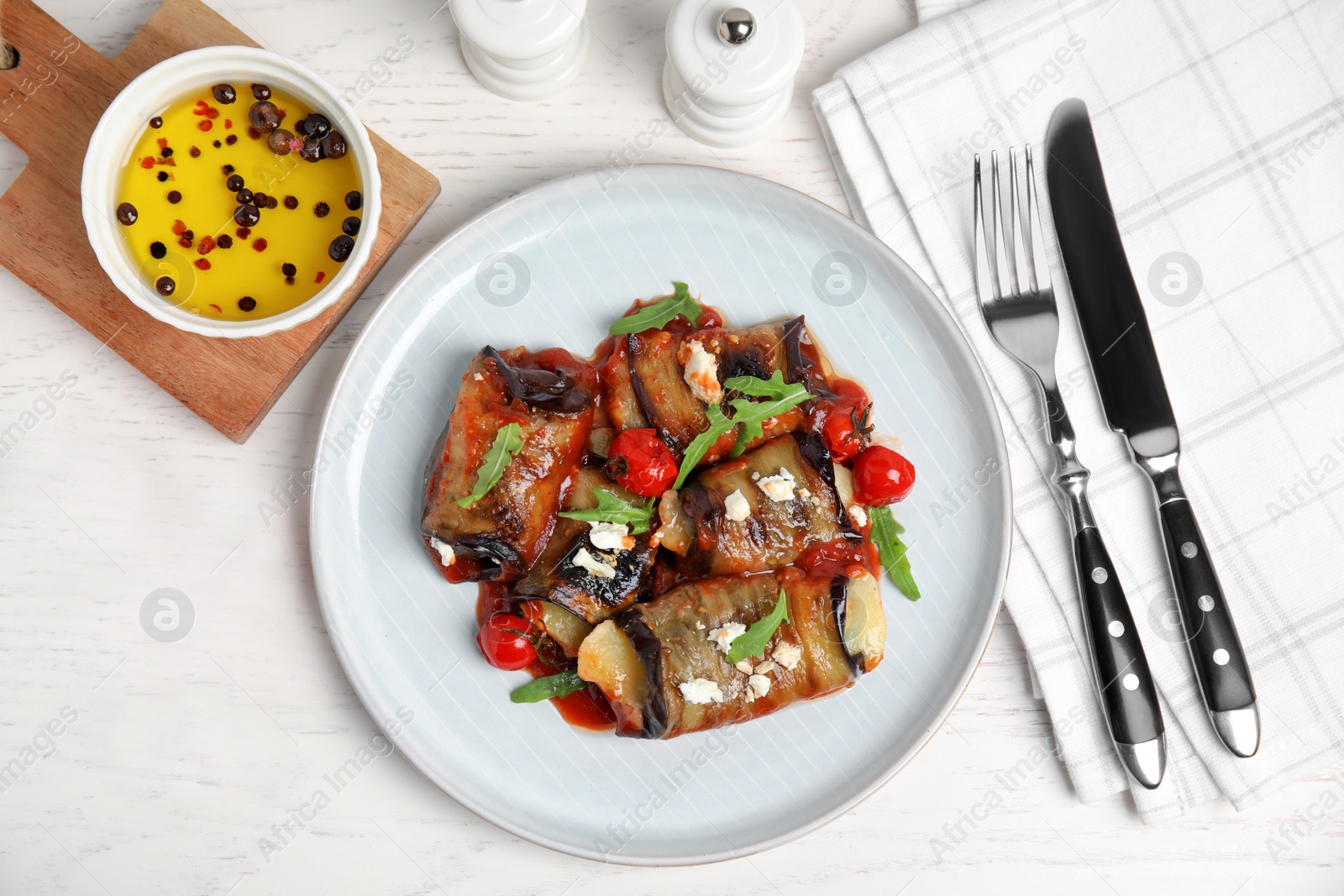 Photo of Delicious baked eggplant rolls served on white wooden table, flat lay