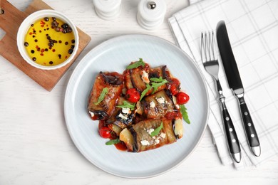 Photo of Delicious baked eggplant rolls served on white wooden table, flat lay