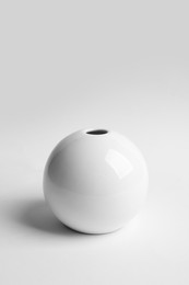 Photo of Stylish white ceramic vase on light background