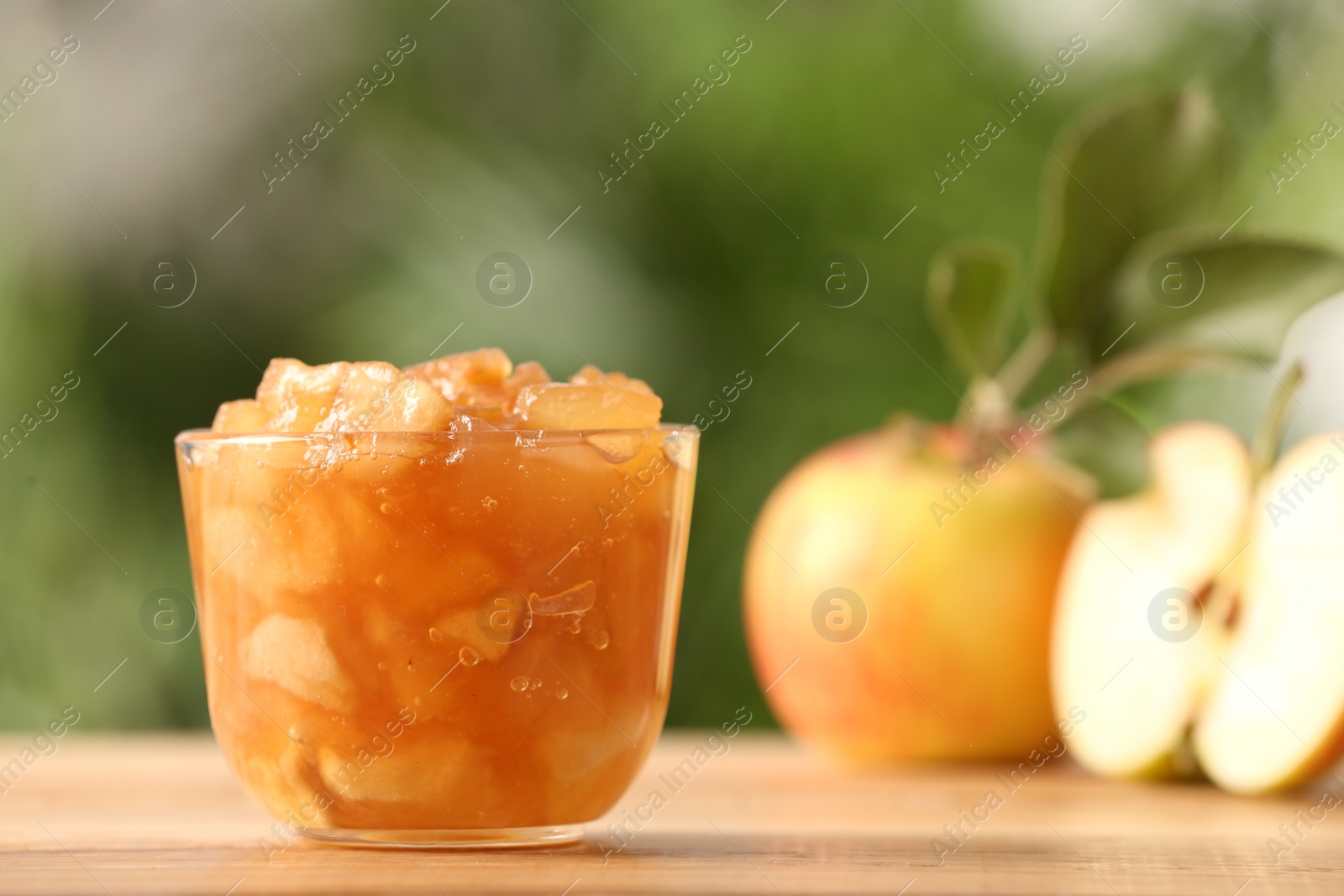 Photo of Delicious apple jam and fresh fruits on wooden table