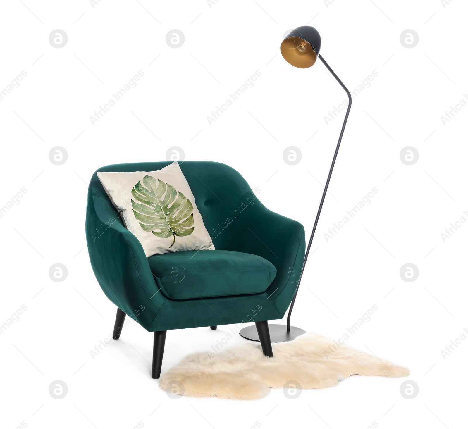 Image of Soft pillow with printed tropical leaf on armchair, lamp and rug against white background