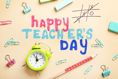 Alarm clock, text HAPPY TEACHER'S DAY and stationery on color paper