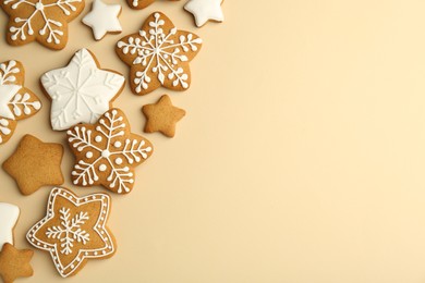 Photo of Tasty Christmas cookies with icing on beige background, flat lay. Space for text