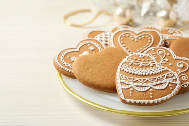 Tasty heart shaped gingerbread cookies on white wooden table, closeup