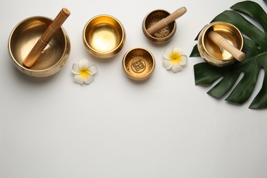 Photo of Flat lay composition with golden singing bowls on white background. Space for text