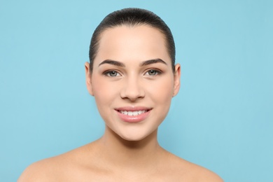 Photo of Portrait of young woman with beautiful face and natural makeup on color background