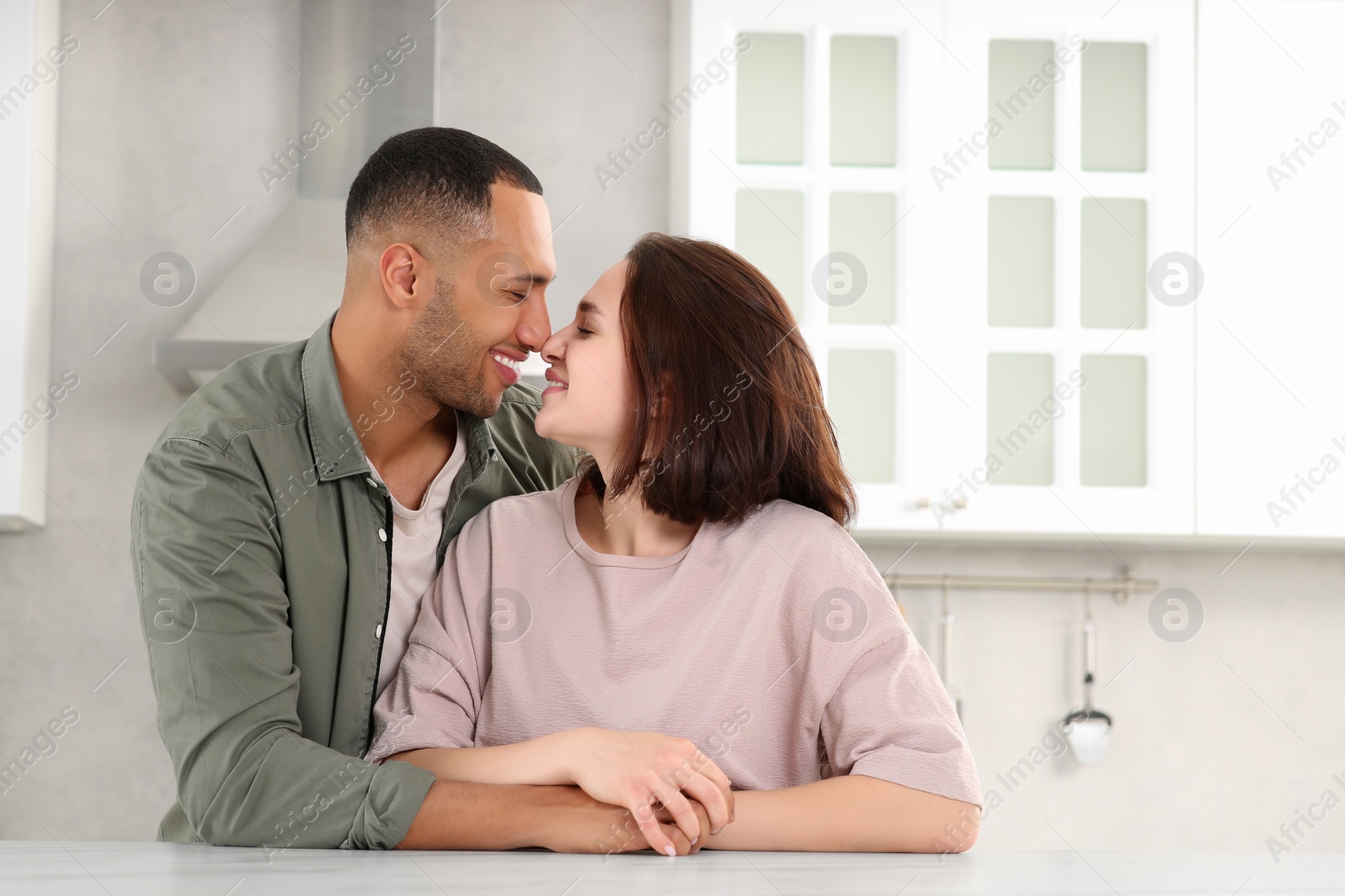 Photo of Dating agency. Happy couple spending time together in kitchen, space for text