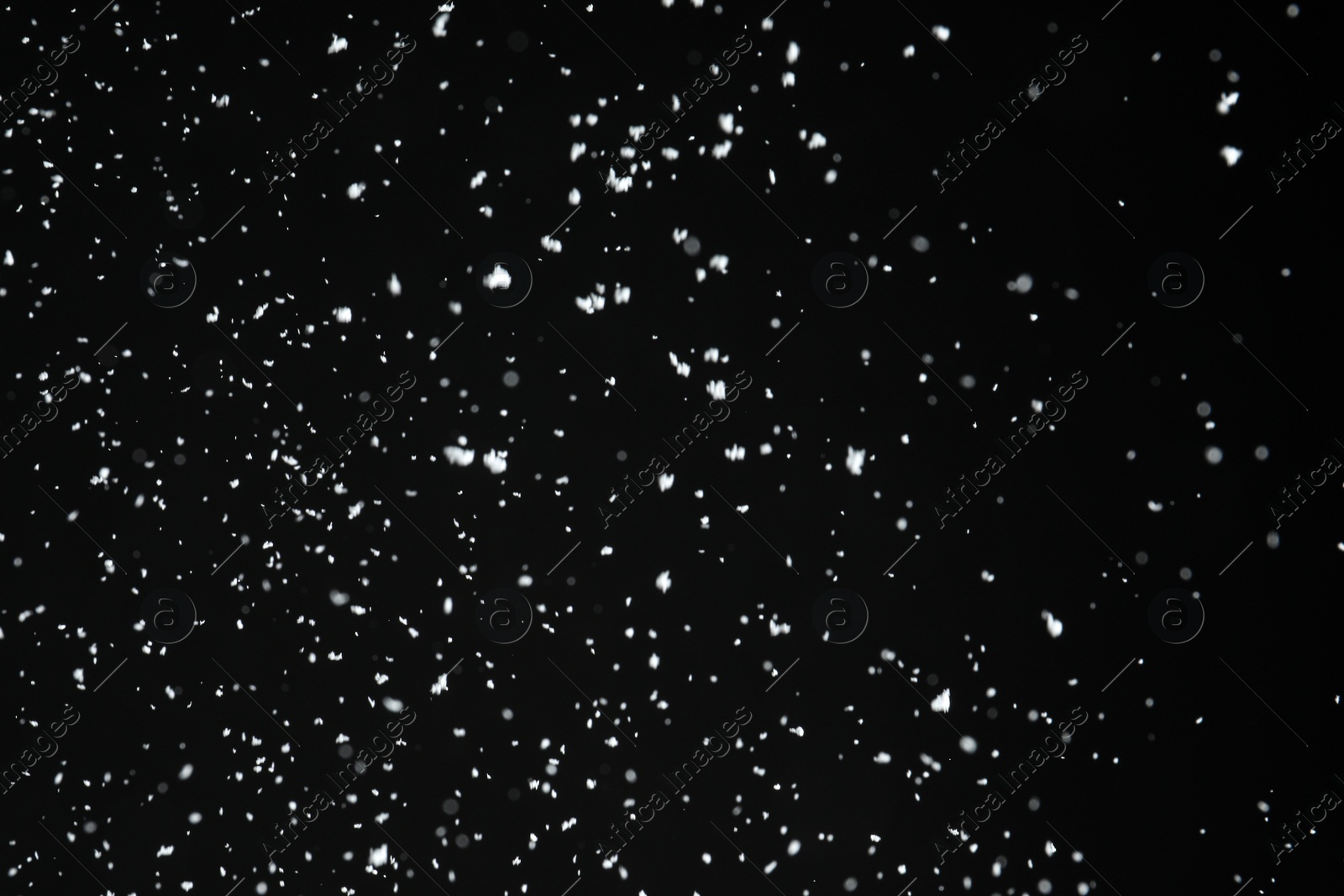 Photo of White snow falling down on black background