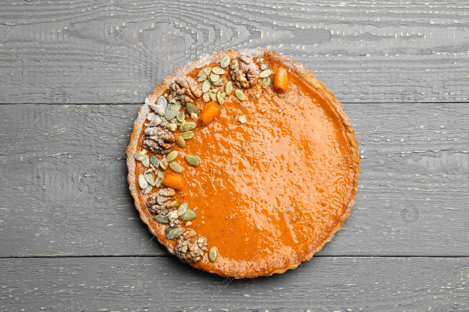 Photo of Delicious fresh homemade pumpkin pie on grey wooden table, top view