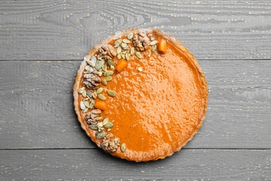 Photo of Delicious fresh homemade pumpkin pie on grey wooden table, top view