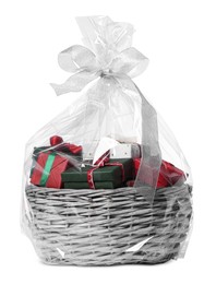 Wicker basket full of gift boxes on white background