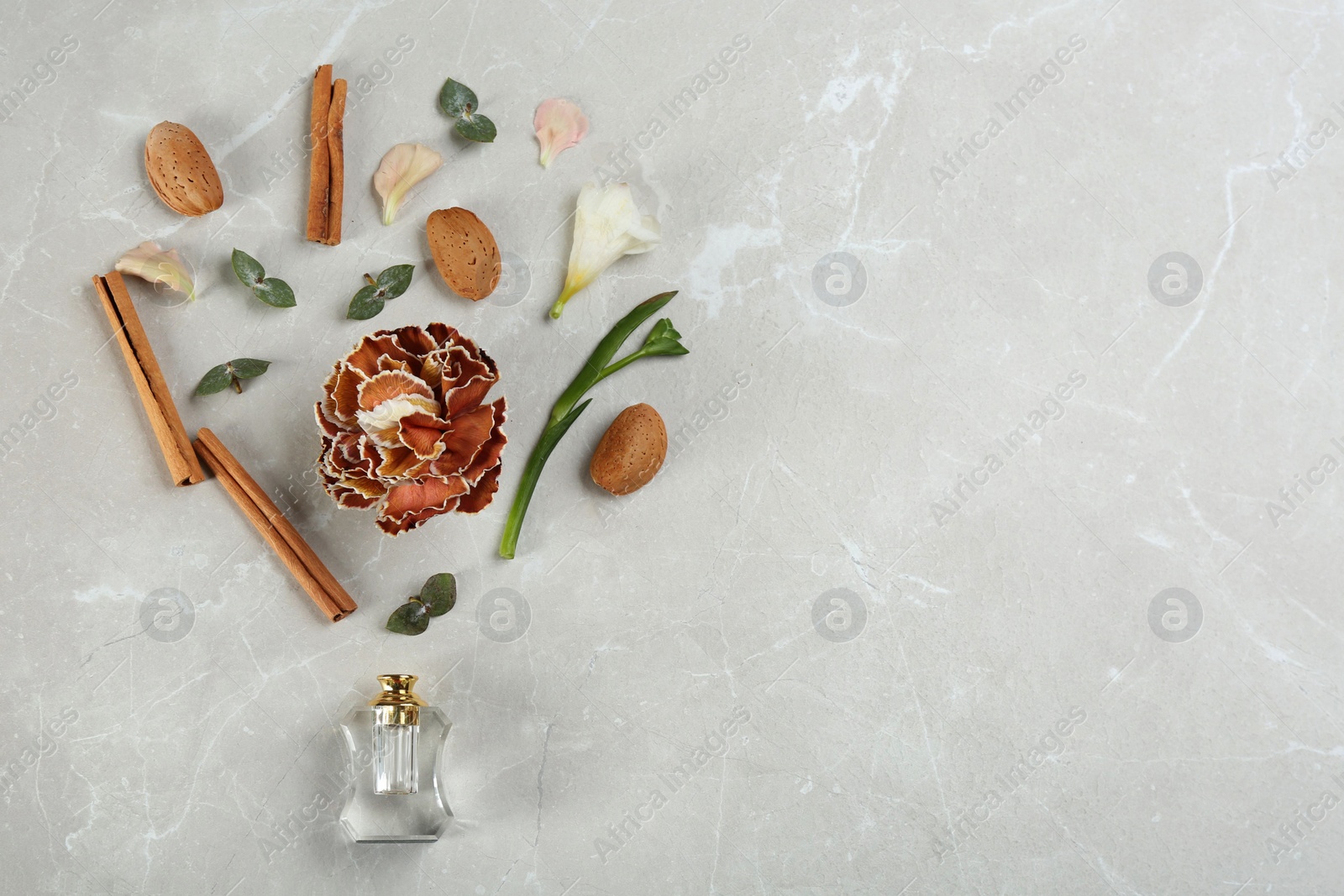 Photo of Flat lay composition with bottle of perfume on marble background, space for text