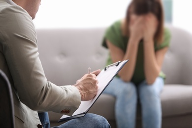 Psychotherapist working with woman in office, closeup