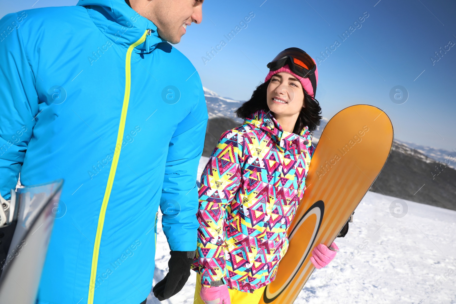 Photo of Couple with snowboards at ski resort. Winter vacation