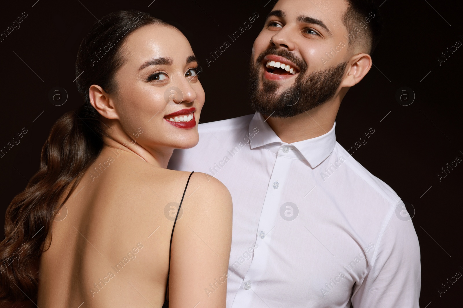 Photo of Handsome bearded man with sexy lady on dark background