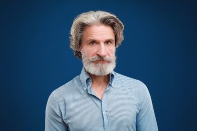 Photo of Portrait of handsome mature man on blue background