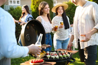 Group of friends having barbecue party outdoors