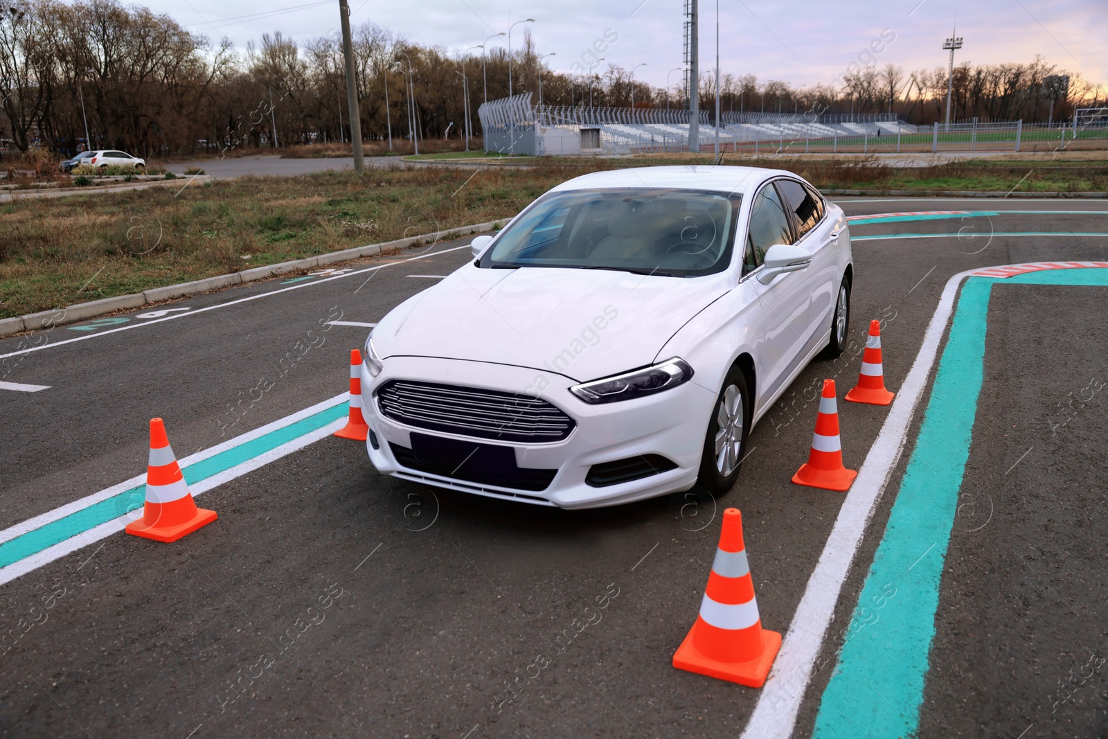 Photo of Modern car on driving school test track with traffic cones