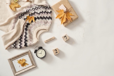 Photo of Flat lay composition with cozy knitted sweater on white background. Space for text