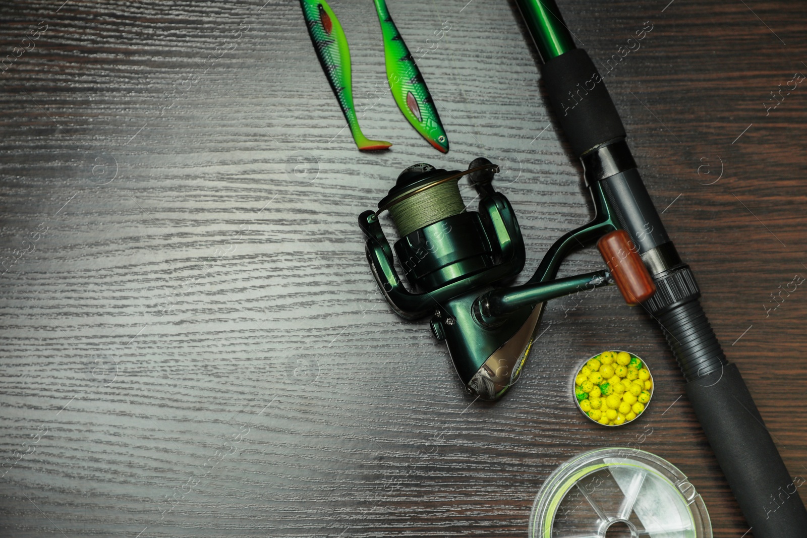 Photo of Fishing tackle on dark wooden background, flat lay. Space for text