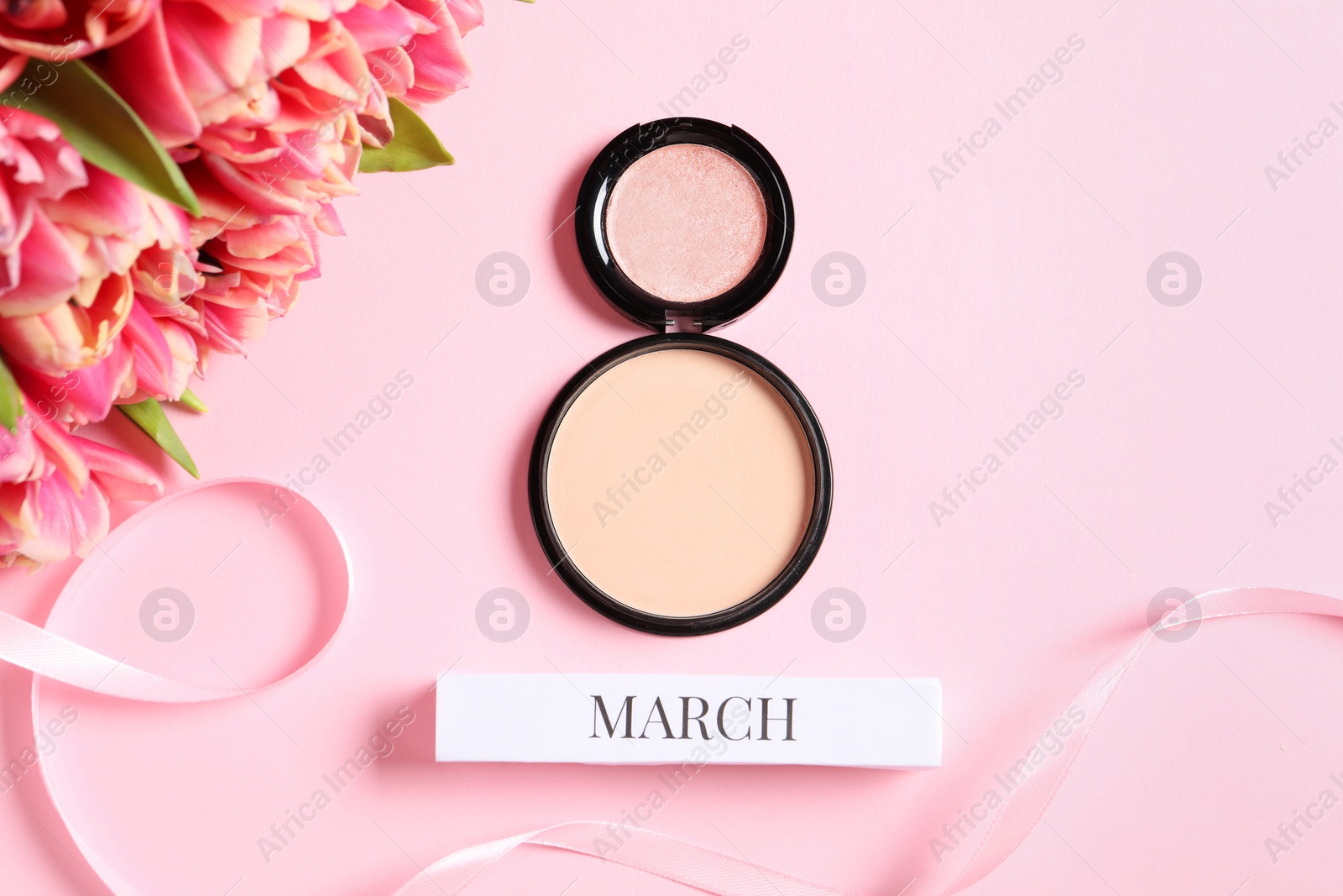 Photo of International Women's day. 8th of March made with makeup powder and beautiful tulips on pink background, flat lay