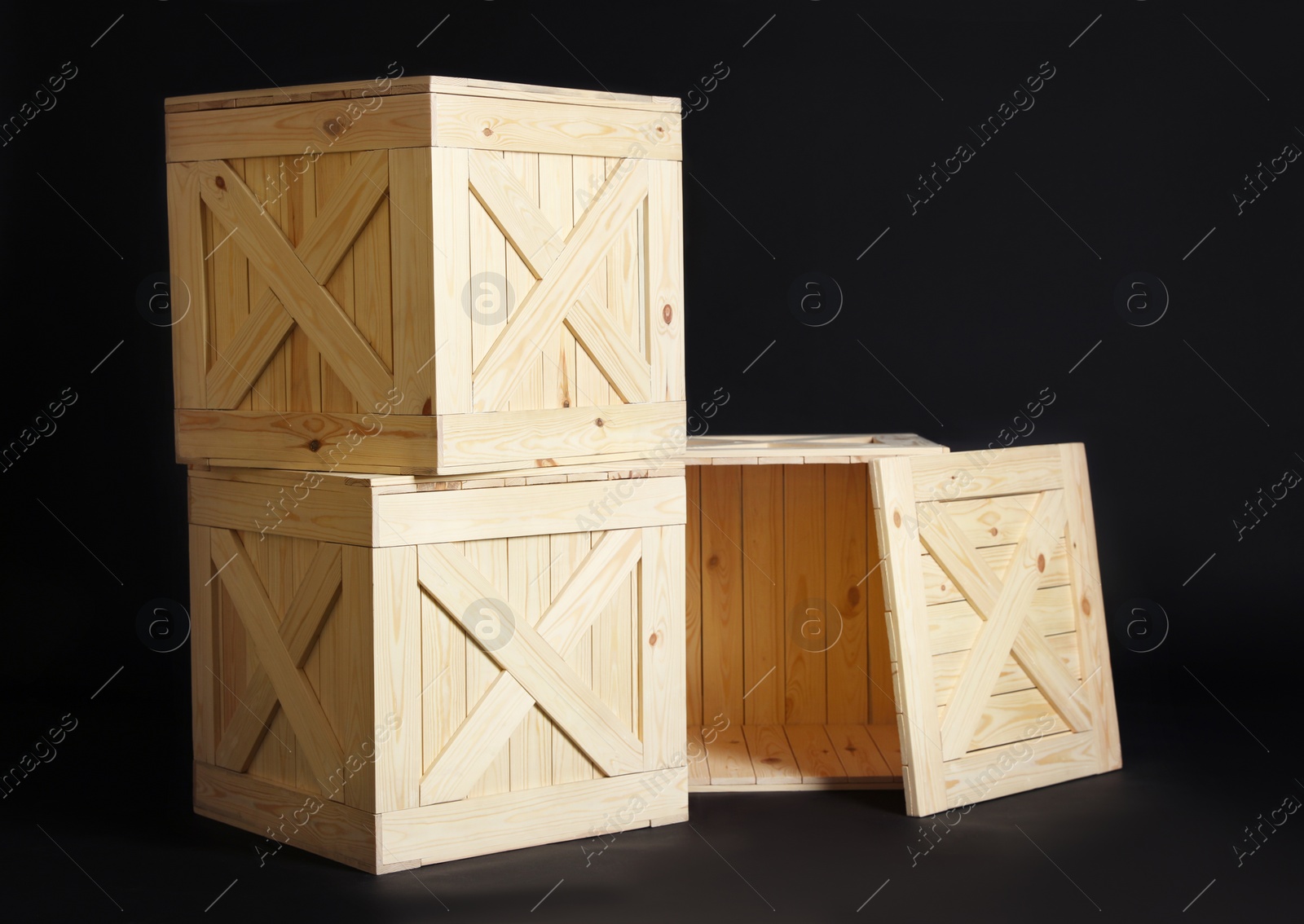 Photo of Group of wooden crates on black background