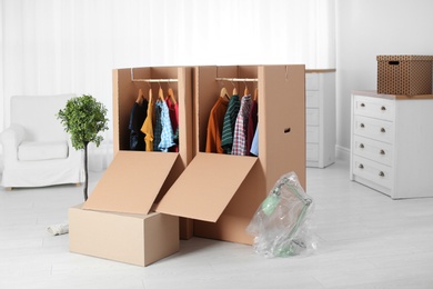 Photo of Wardrobe boxes with clothes in room interior