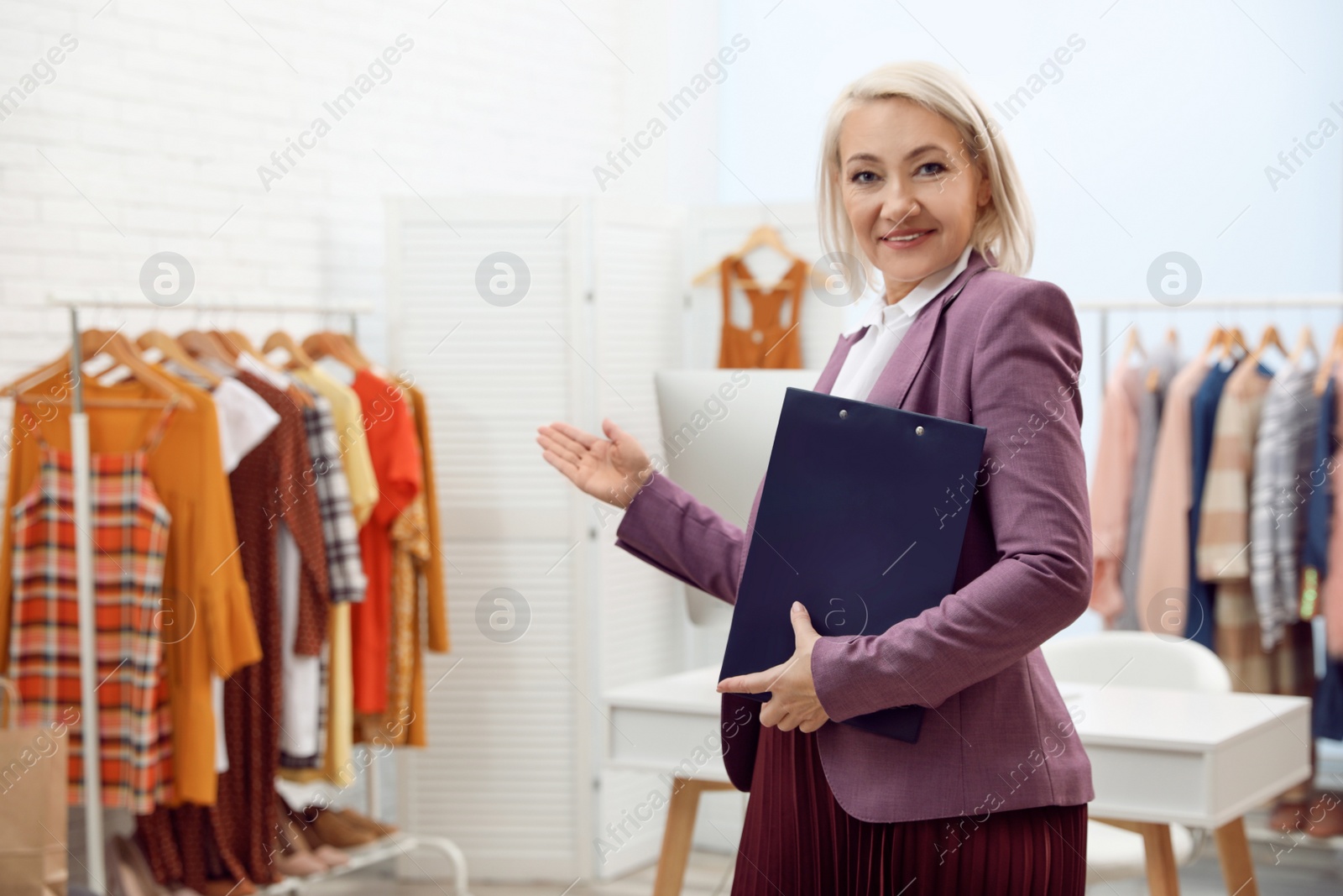 Photo of Female business owner with clipboard in boutique