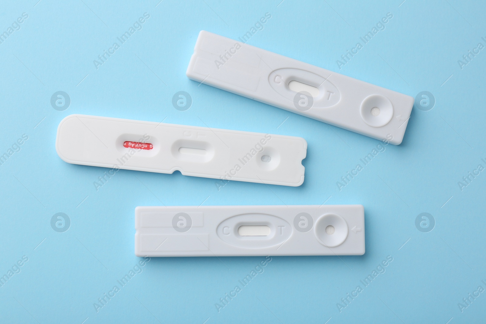 Photo of Different disposable express tests on light blue background, flat lay