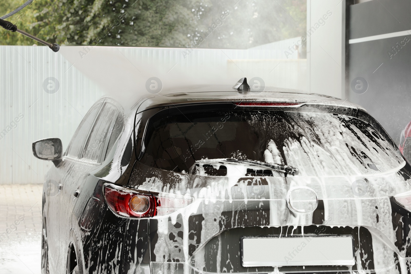 Photo of Washing auto with high pressure water jet at outdoor car wash