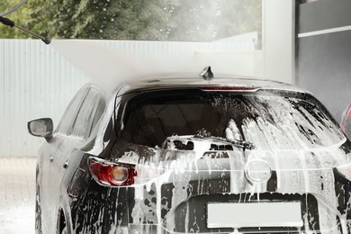 Photo of Washing auto with high pressure water jet at outdoor car wash