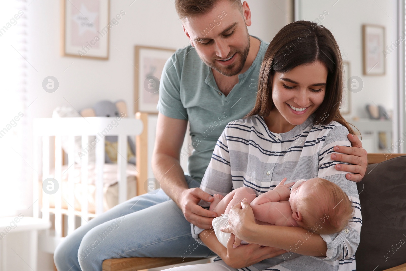 Photo of Happy couple with their newborn baby at home