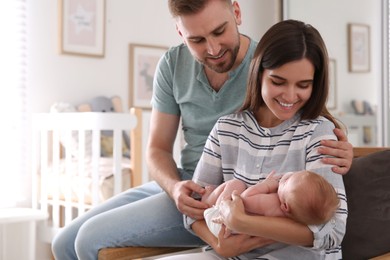 Photo of Happy couple with their newborn baby at home