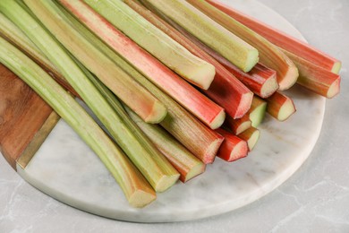 Fresh ripe rhubarb stalks on light grey table, closeup