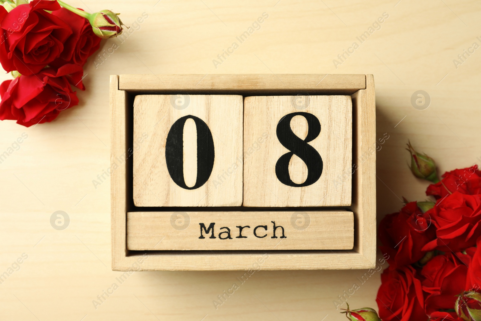 Photo of Block calendar with date 8th of March and roses on wooden background, flat lay. International Women's Day