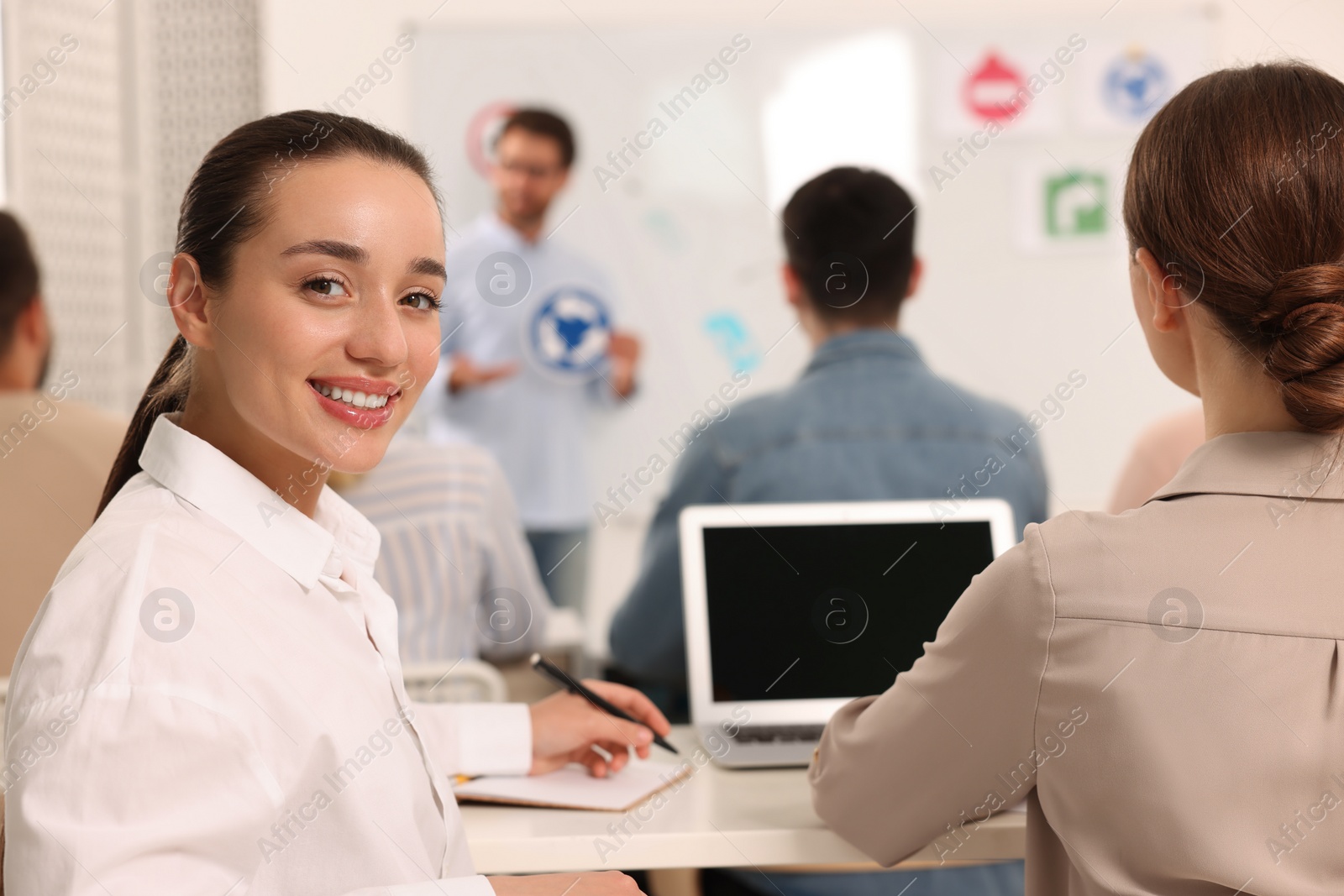 Photo of Happy woman at desk in class during lesson in driving school