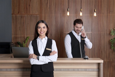 Photo of Receptionist at desk with colleague in lobby