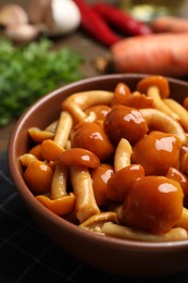 Photo of Tasty marinated mushrooms in bowl on table, closeup