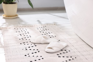 White soft slippers on carpet at home