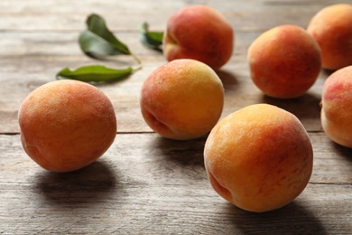 Photo of Fresh sweet peaches on wooden table, closeup