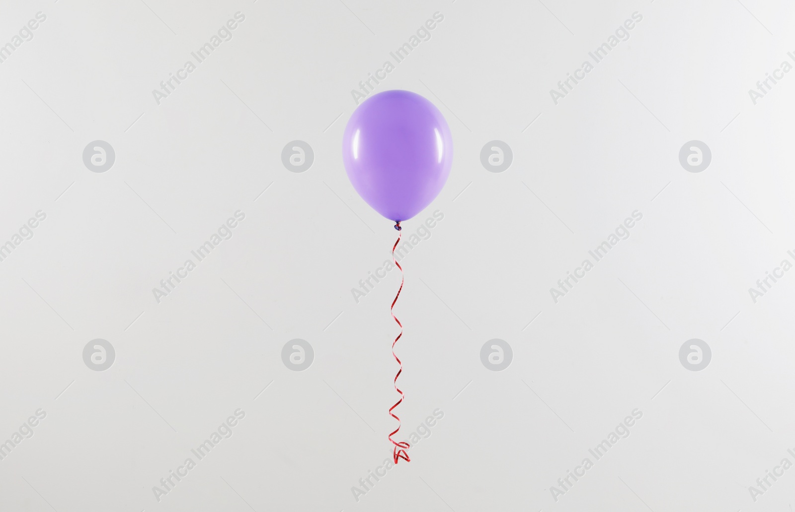 Photo of Bright balloon on light background. Celebration time