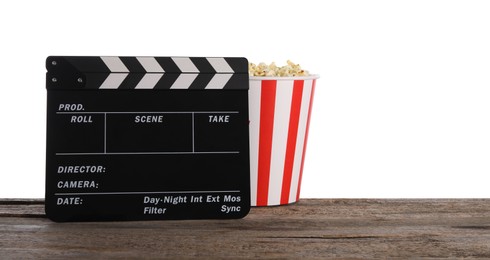 Photo of Movie clapper and bucket of tasty popcorn on wooden table against white background, space for text