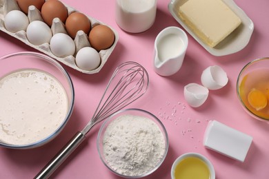 Photo of Composition with whisk and dough in bowl on pink background, flat lay